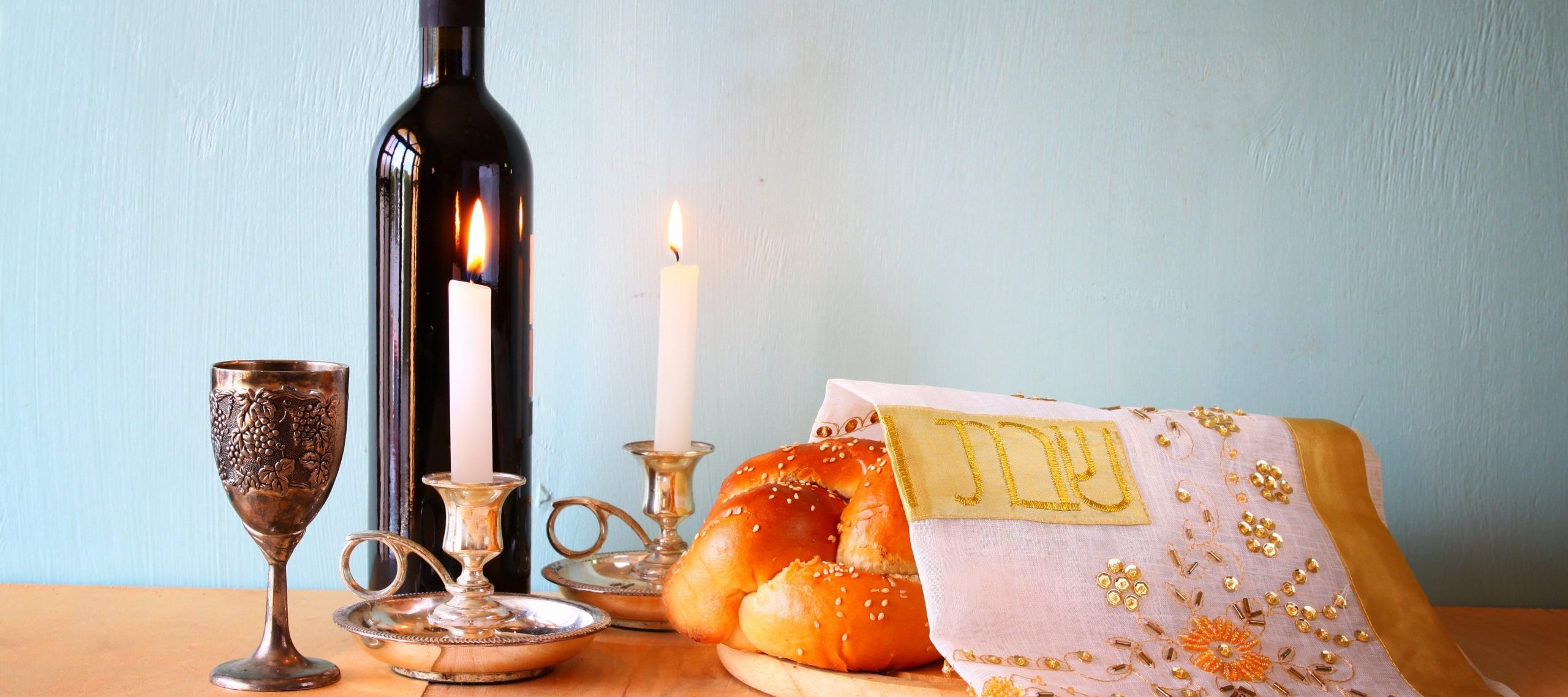 shabbat image. challah bread, shabbat wine and candelas on woode