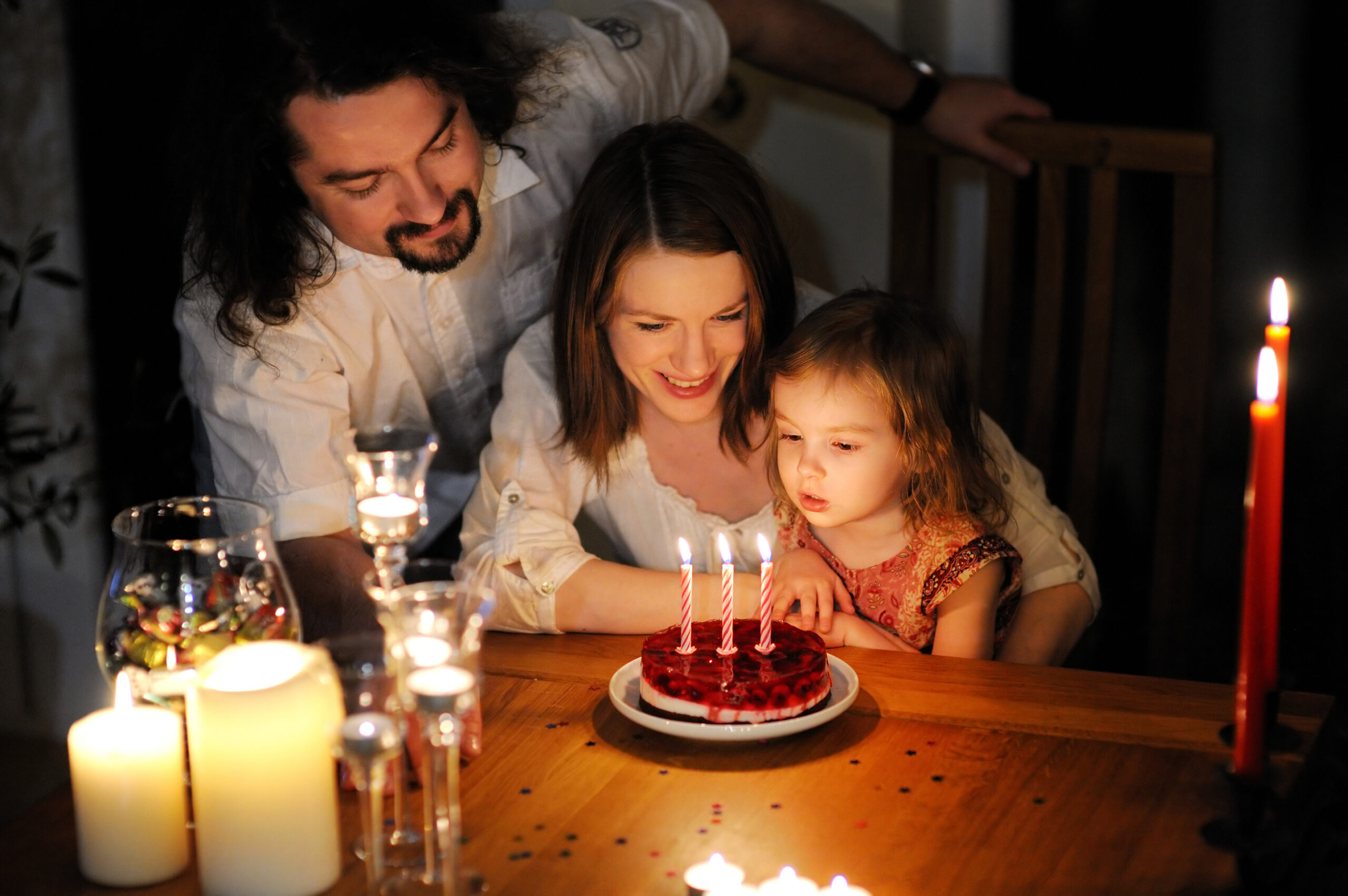 Happy family celebrating their daughter's third birthday