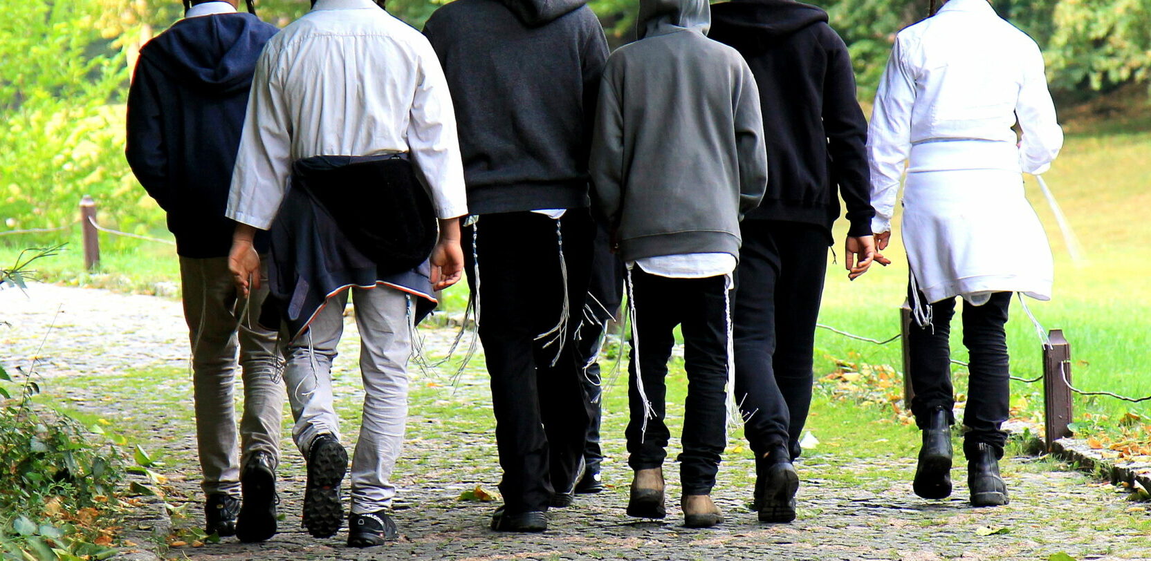 Young Jewish Hasidic men are walking in Uman, Ukraine. On their