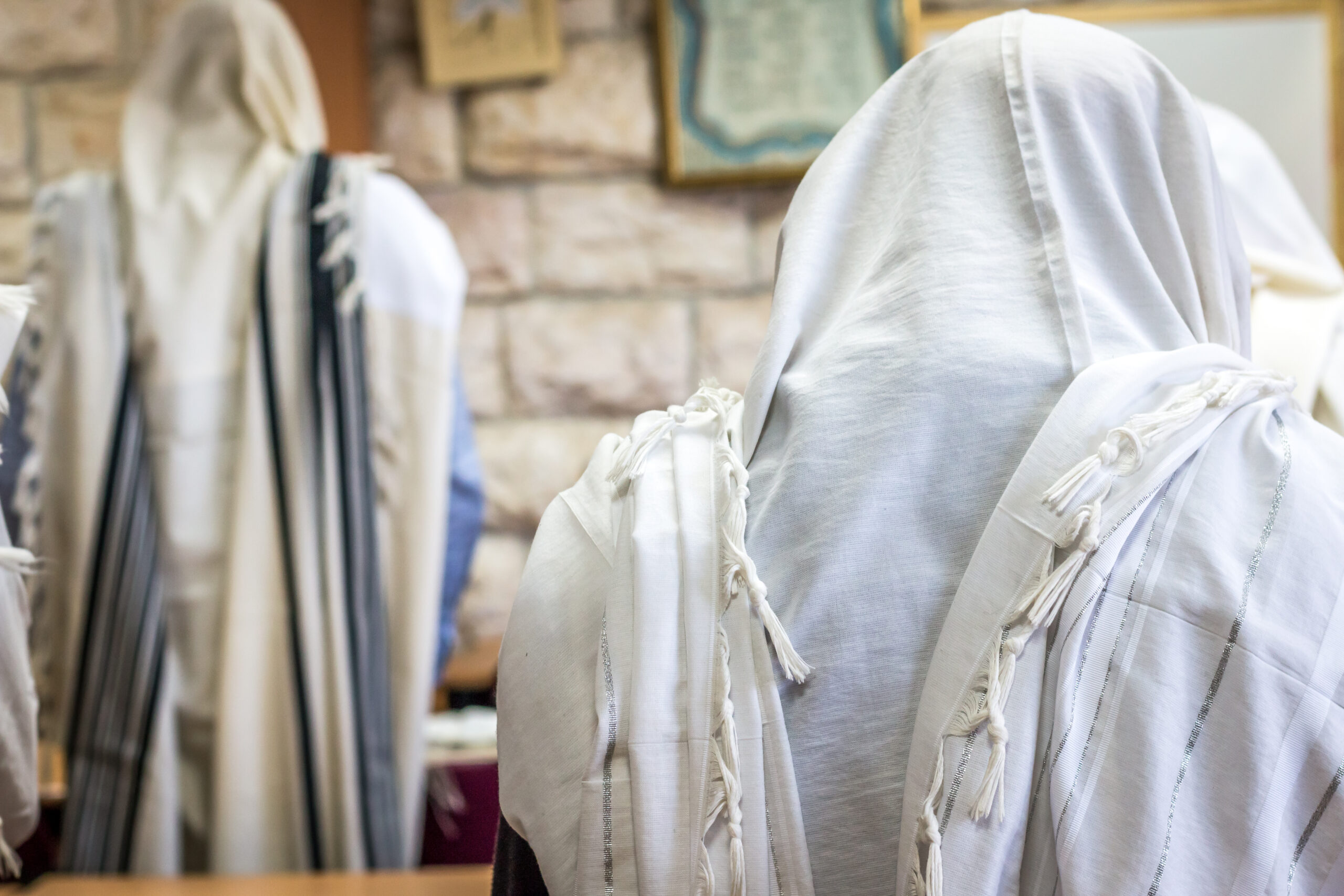 Jewish men praying in a synagogue with Tallit